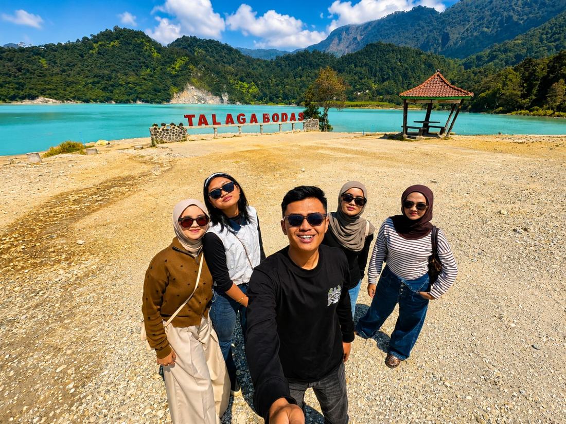 Tamu berfoto di tepi Talaga Bodas yang berair putih kebiruan